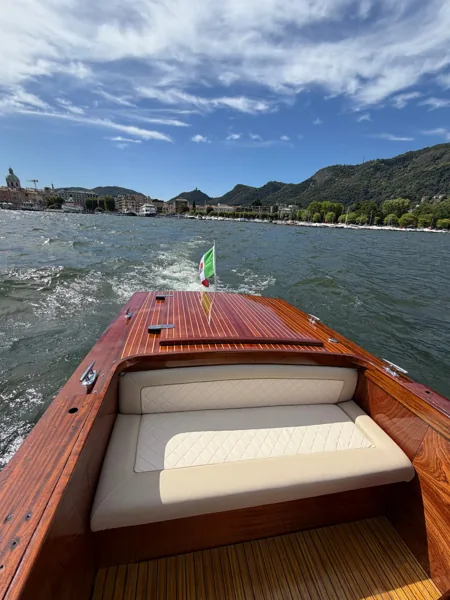 Vista dalla prua di un taxi in legno verso Como e il suo duomo